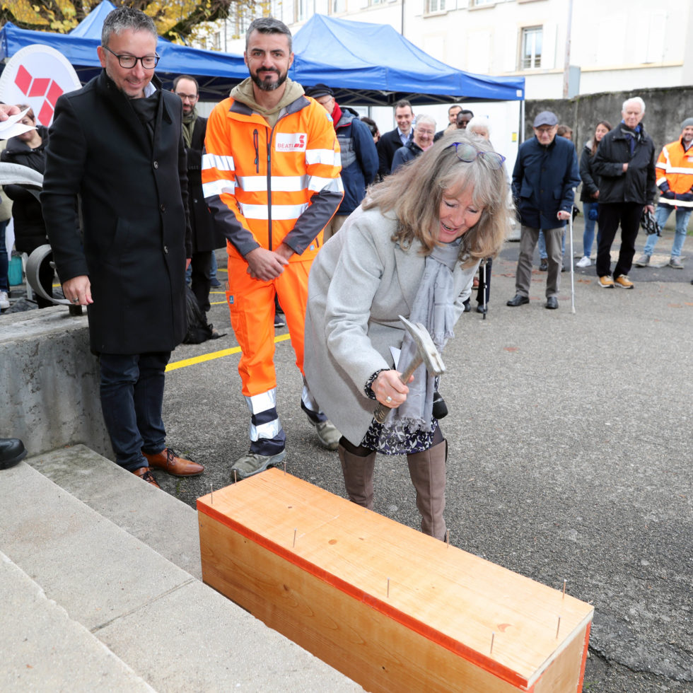 La Présidente du Conseil de paroisse cloue la capsule temporelle contenant les plans du CCNV
